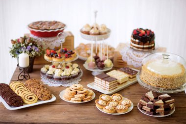 Table with various cookies, tarts, cakes, cupcakes and cakepops clipart