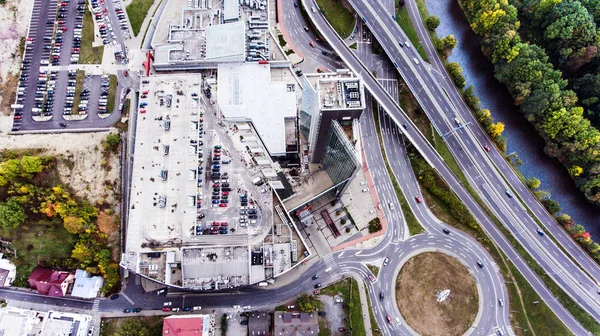 Luchtfoto, gebouw, eigen parkeerplaats en snelweg passeren door de stad — Stockfoto