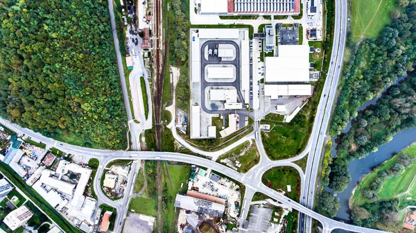 Vista aérea de edifícios industriais, rodovia e pequena cidade — Fotografia de Stock