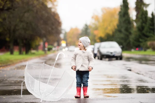 Bambina con ombrello trasparente all'esterno, giornata piovosa . — Foto Stock