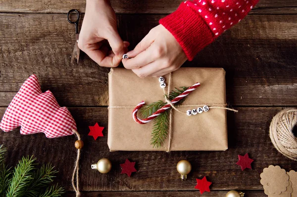 Mujer irreconocible envolviendo y decorando regalo de Navidad — Foto de Stock