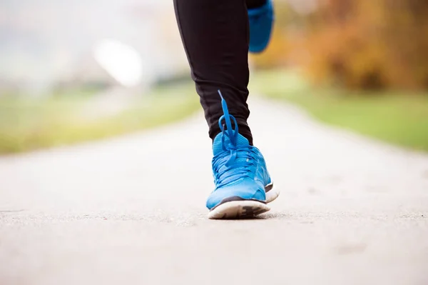 Benen voor onherkenbaar runner joggen op concrete pad, close-up — Stockfoto