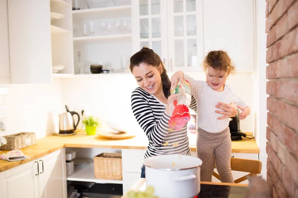 Madre con su hija en la cocina cocinando juntos —  Fotos de Stock