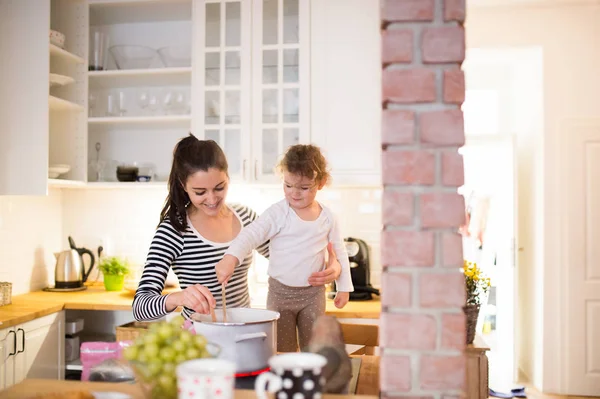 Madre con su hija en la cocina cocinando juntos —  Fotos de Stock