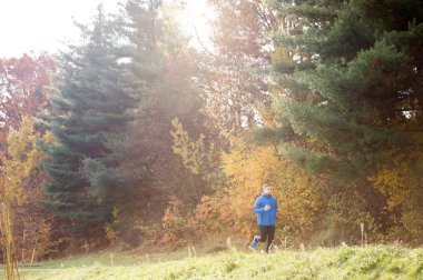 Renkli sonbahar n karşı çalışan genç yakışıklı hipster atlet