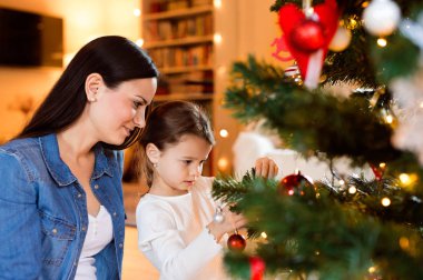 Genç anne ile birlikte Noel ağacı süsleme daugter.