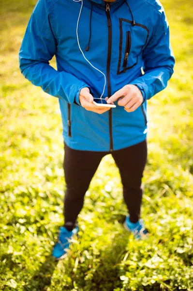 Oigenkännlig löpare med smart telefon, appen fitness — Stockfoto