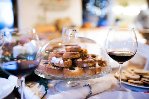 Pranzo di Natale su un tavolo. Pasticceria e vino rosso . — Foto Stock