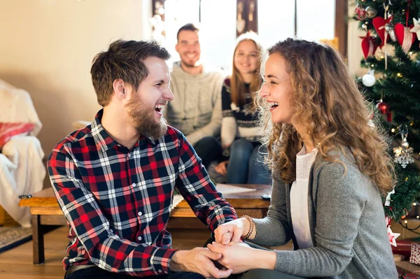 Junge Freunde am geschmückten Weihnachtsbaum feiern Weihnachten — Stockfoto