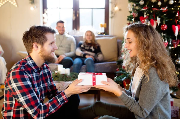 Jonge vrienden bij de versierde kerstboom we vieren kerst — Stockfoto