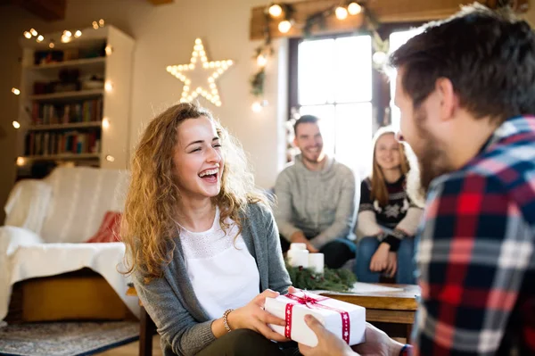Junge Freunde im geschmückten Wohnzimmer feiern Weihnachten zusammen — Stockfoto