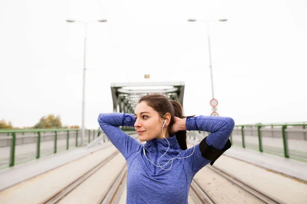 Joven corredor en la ciudad que se extiende en el puente de acero verde — Foto de Stock