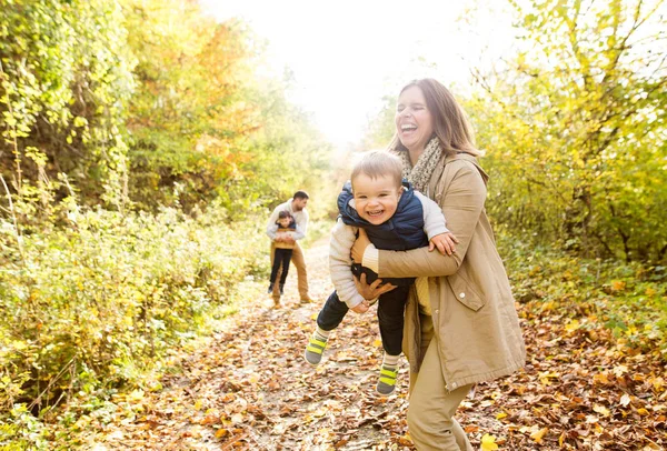 Beautiful young family on a walk in autumn forest. — Stock Photo, Image