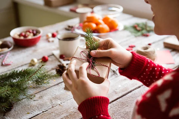 Mujer irreconocible envolviendo y decorando regalo de Navidad — Foto de Stock