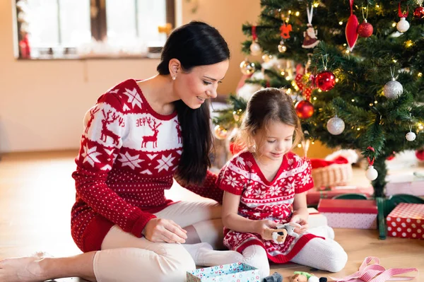 Young mother with daugter at Christmas tree at home. — Stock Photo, Image