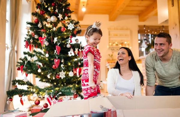 Young family with daugter at Christmas tree at home. — Stock Photo, Image