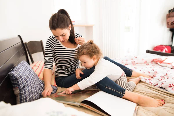 Moeder met plezier met haar dochter in haar slaapkamer — Stockfoto