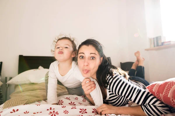 Mutter hat Spaß mit ihrer Tochter im Schlafzimmer — Stockfoto