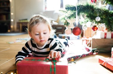 Küçük kız arasında Noel ağacının altında yalan sunar