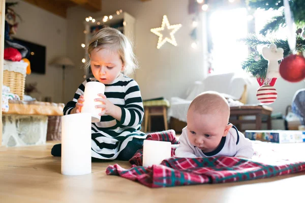 Kleine jongen en meisje onder de kerstboom, meisje speelt met cand — Stockfoto