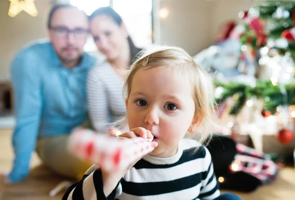 Pais com filha na árvore de Natal soprando apito festa — Fotografia de Stock