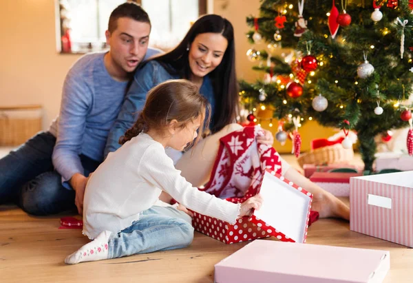 Ung familj med daugter på julgran hemma. — Stockfoto