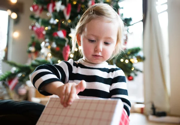 Malá holčička v otevírání přítomné vánoční stromeček — Stock fotografie