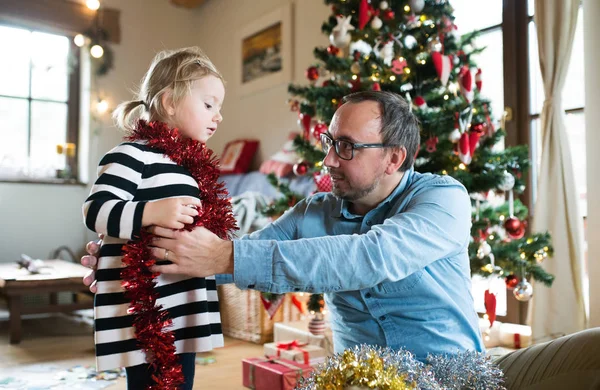 Vader met daugter versieren kerstboom, inwikkeling van klatergoud een — Stockfoto