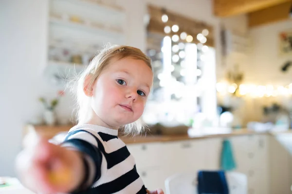 Linda niña en vestido a rayas sentado en la mesa de la cocina. Chri. —  Fotos de Stock