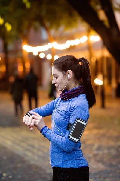 Young woman in blue sweatshirt running in the night town