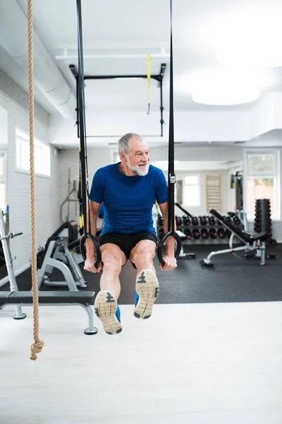 Äldre mannen i gym tränar på Gymnastringar — Stockfoto