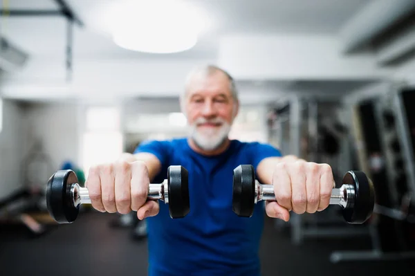 Äldre mannen i gymmet träna med vikter. — Stockfoto