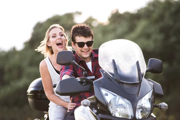 Couple in love enjoying a motorbike ride in countryside. — Stock Photo, Image