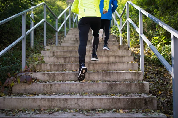 Atletas irreconhecíveis correndo em escadas no dia ensolarado de outono . — Fotografia de Stock