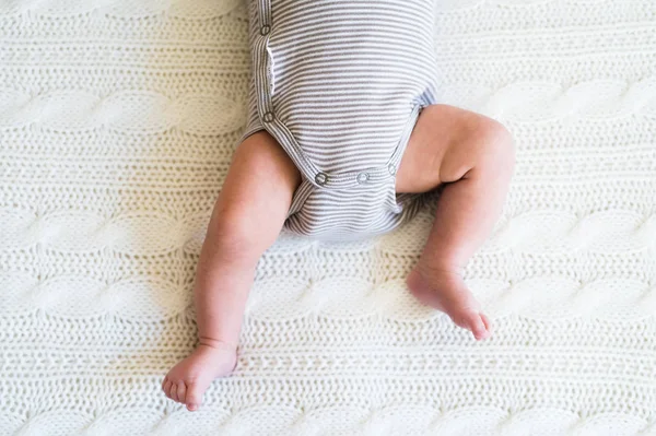 Unrecognizable baby boy lying on bed, close up — Stock Photo, Image
