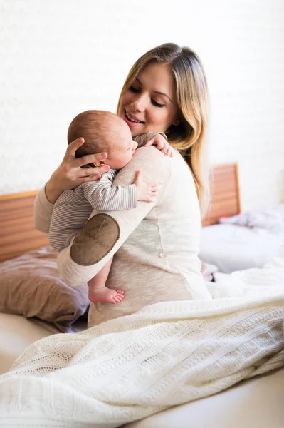 Güzel genç anne kucağında bebek evlat holding — Stok fotoğraf