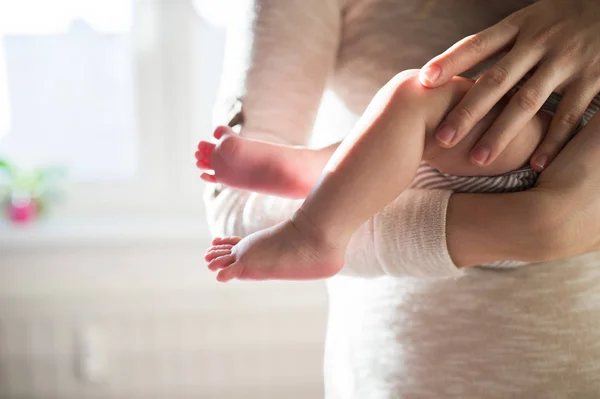 Yeni doğan bebek evlat, bacaklar ve eller ile tanınmaz halde anne — Stok fotoğraf