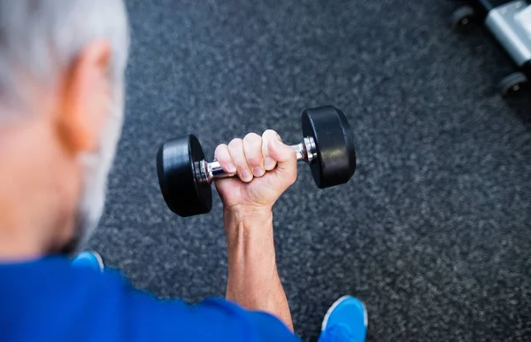 Homme âgé méconnaissable dans la salle de gym travailler avec des poids . — Photo