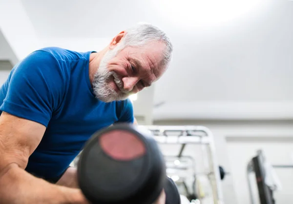 Senior dans la salle de gym travailler avec des poids . — Photo