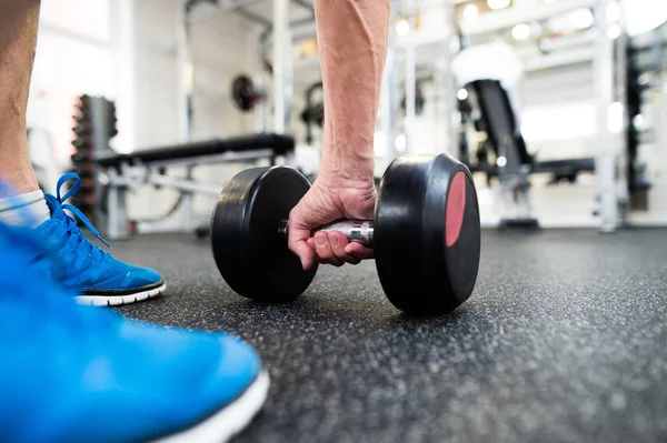 Hombre mayor irreconocible en el gimnasio haciendo ejercicio con pesas — Foto de Stock