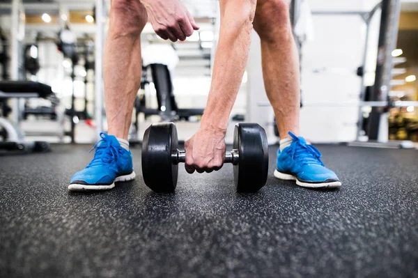 Hombre mayor irreconocible en el gimnasio haciendo ejercicio con pesas — Foto de Stock