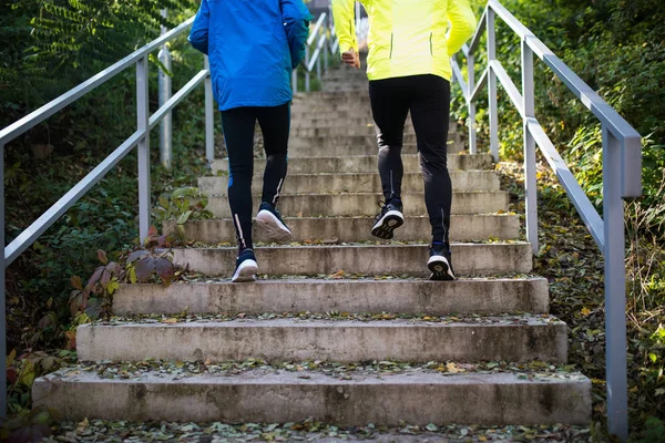 Felismerhetetlen sportolók, futás, lépcsőn a napsütéses őszi napon. — Stock Fotó