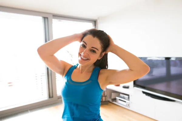 Junge Frau übt zu Hause, streckt den Nacken. — Stockfoto