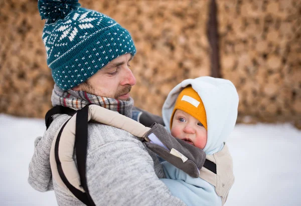 Baba holding oğul bebek taşıyıcı içinde. Kış Doğa. — Stok fotoğraf