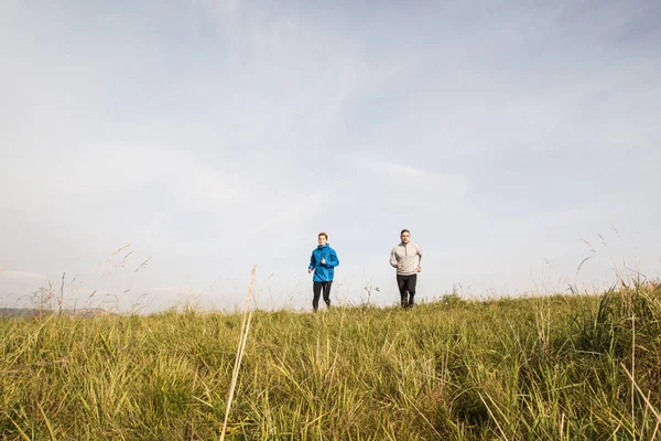 Dos jóvenes atletas hipster corriendo en la soleada naturaleza otoñal —  Fotos de Stock