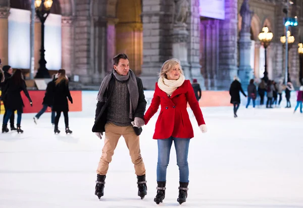 美丽的高级夫妇滑冰在城市中心。冬天 — 图库照片