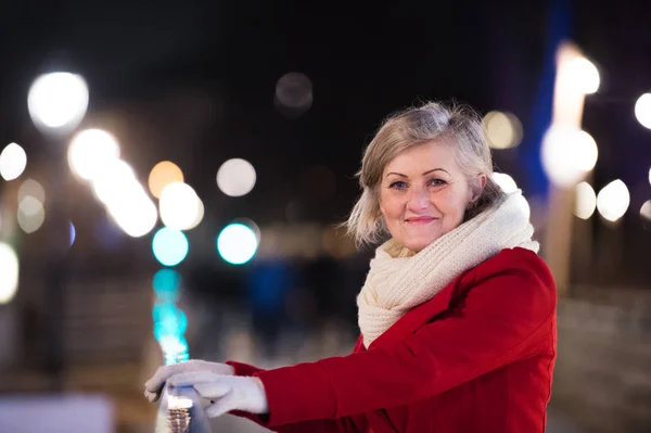 Старша жінка на прогулянці в нічному місті. Зима — стокове фото