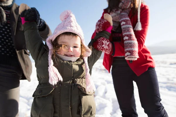 Genitori irriconoscibili con la figlia in una passeggiata in inverno — Foto Stock