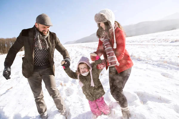 Vader en moeder met hun dochter, spelen in de sneeuw. — Stockfoto