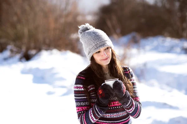 Bella giovane donna con tazza di caffè nella natura invernale — Foto Stock